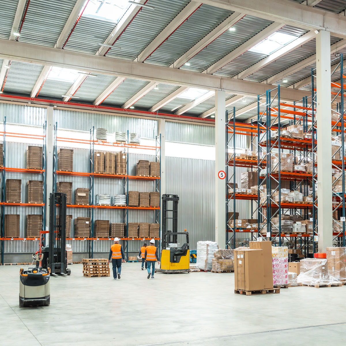 Interior of a warehouse with tall storage racks and a forklift
