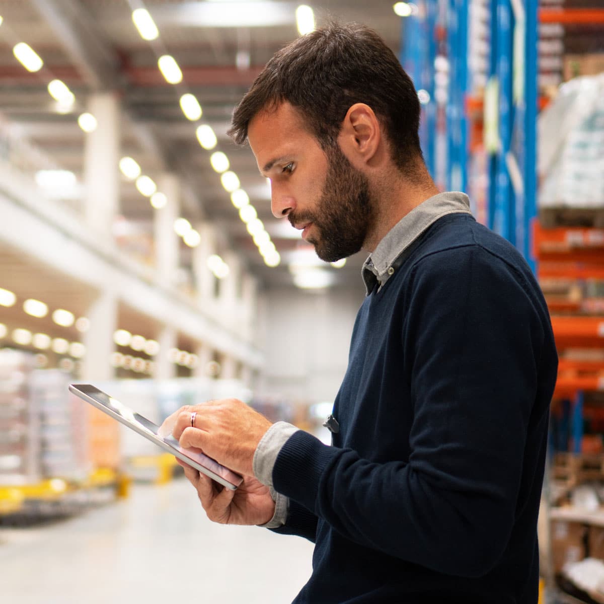 Worker using a tablet in a warehouse aisle