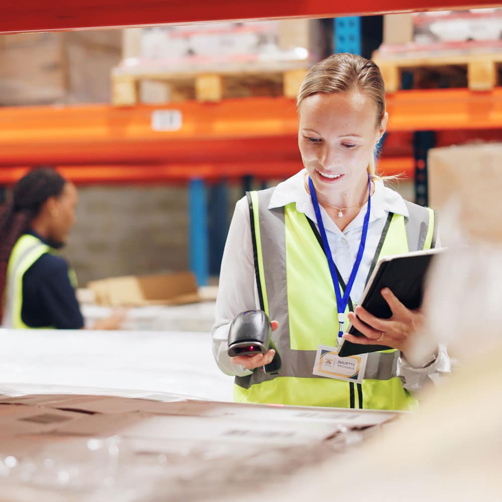 Warehouse worker in a hi-vis vest using a handheld scanner