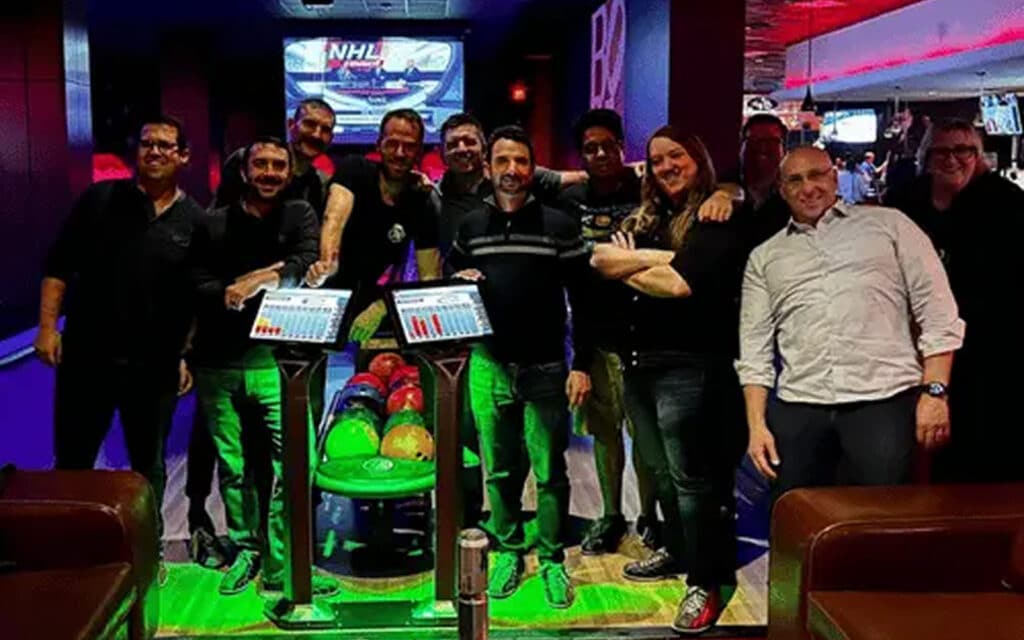 about-slider-13 Cycle Labs team group photo at a bowling alley with bowling balls in the foreground