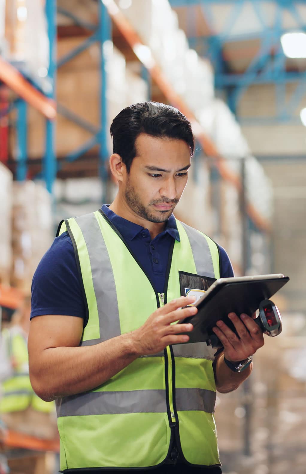 Warehouse worker viewing data on a tablet in a distribution center